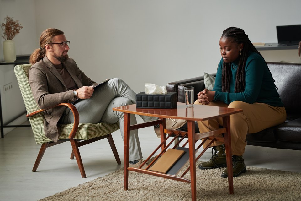 A parent and a therapist talking in armchairs across a low table